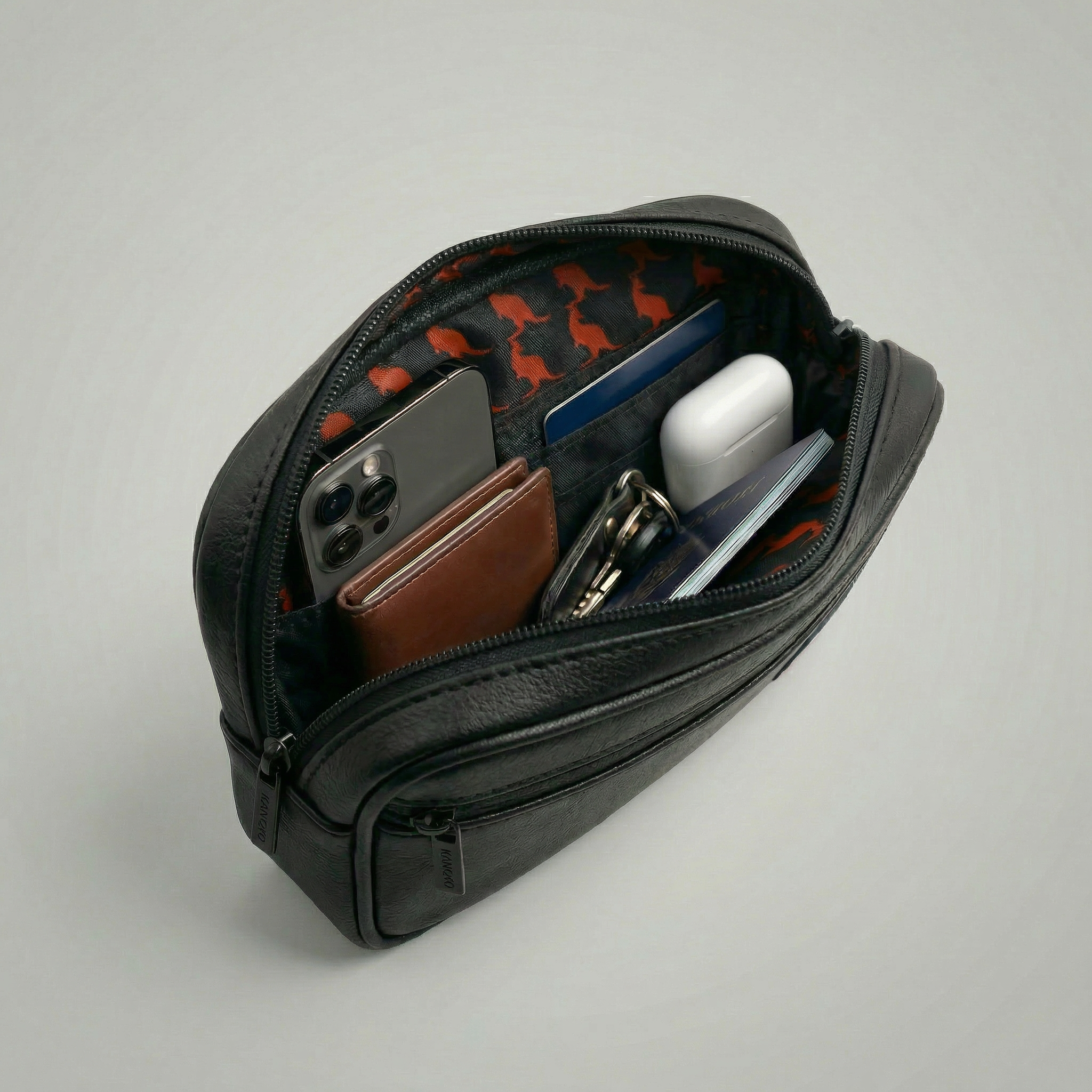 Black leather pouch with compartments containing a phone, wallet, and other items on a light gray background Detachable utility pouch with waterproof zipper and logo patch